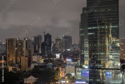 Skyscrapers in the business district of Bangkok city at night under Sprinkling rain. Rainy season, No focus, specifically. © num