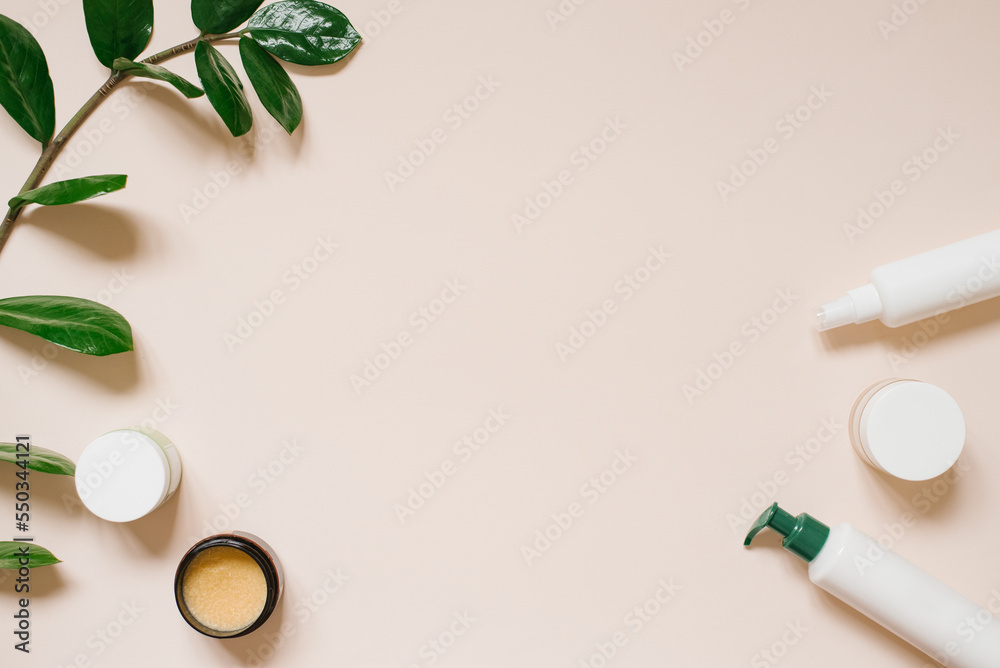 White cosmetic jar and a bottle of cream with a top view of the leaves of plants, a mock-up of the product design. Natural organic cosmetics White cosmetic jar and a bottle of cream with a top view of the leaves of plants, a mock-up of the product design. Natural organic cosmetics