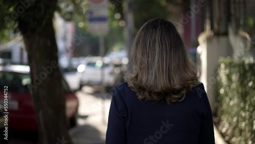 Wallpaper Mural Back of person walking in urban street sidewalk. One Woman walks in city during bright daylight Torontodigital.ca