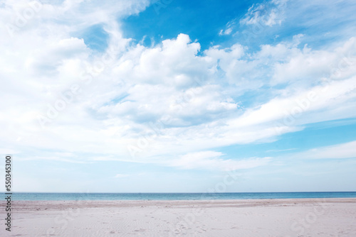 Empty beach with white sand, sea with horizon and cloudscape. Sea background.