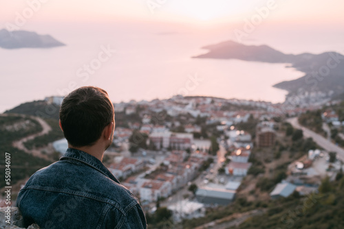 A young man meets on a mountain by the sea meets the sunset.
