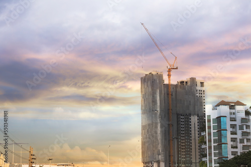 the construction site and tower cranes they try to build a city and building. the tower crane at the sunset serenely.
