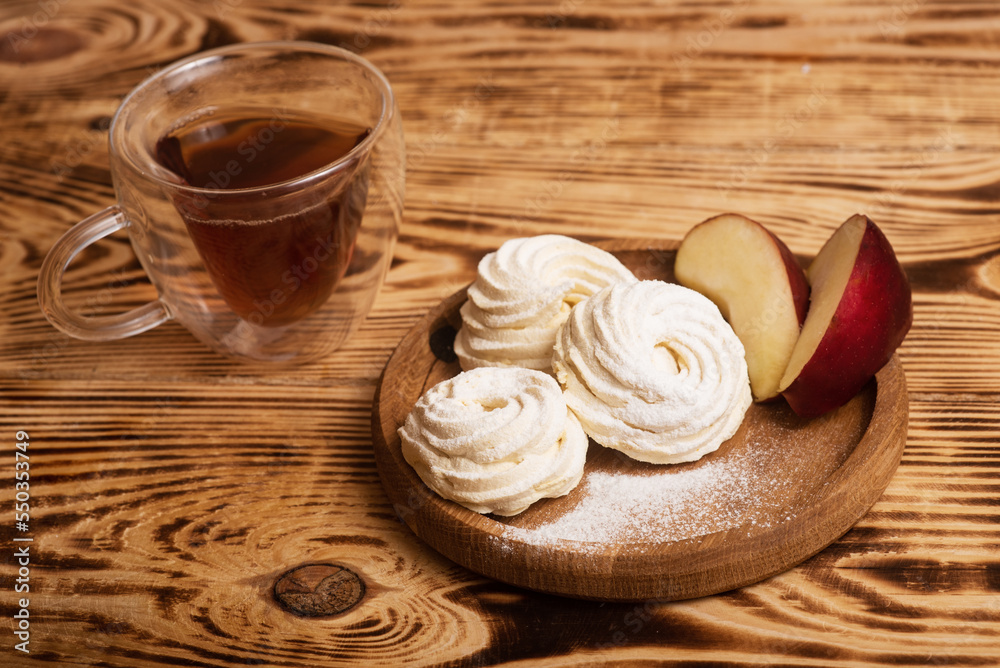 Handmade marshmallow. Natural sweetness. Apple zephir and cup of tea in wood surface