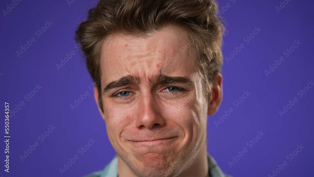 Closeup of sad tired fatigued headache exhausted young man 20s posing isolated on purple background studio. People lifestyle concept. Put hands on head Closeup of sad tired fatigued headache exhausted young man 20s posing isolated on purple background studio. People lifestyle concept. Put hands on head