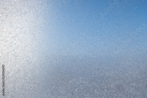 Ice freezes on glass in the cold winter season. Frosty original pattern on winter window glass, natural texture. copy space