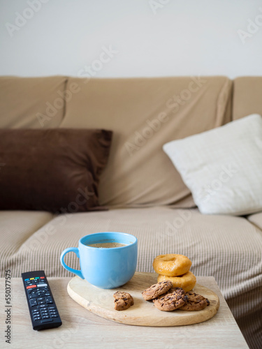 Hot milk with cookie and doughnut for a snack in the living room