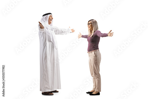 Full length profile shot of a mature arab man in a robe greeting a young woman