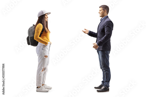 Full length profile shot of a man talking to a female student with a backpack