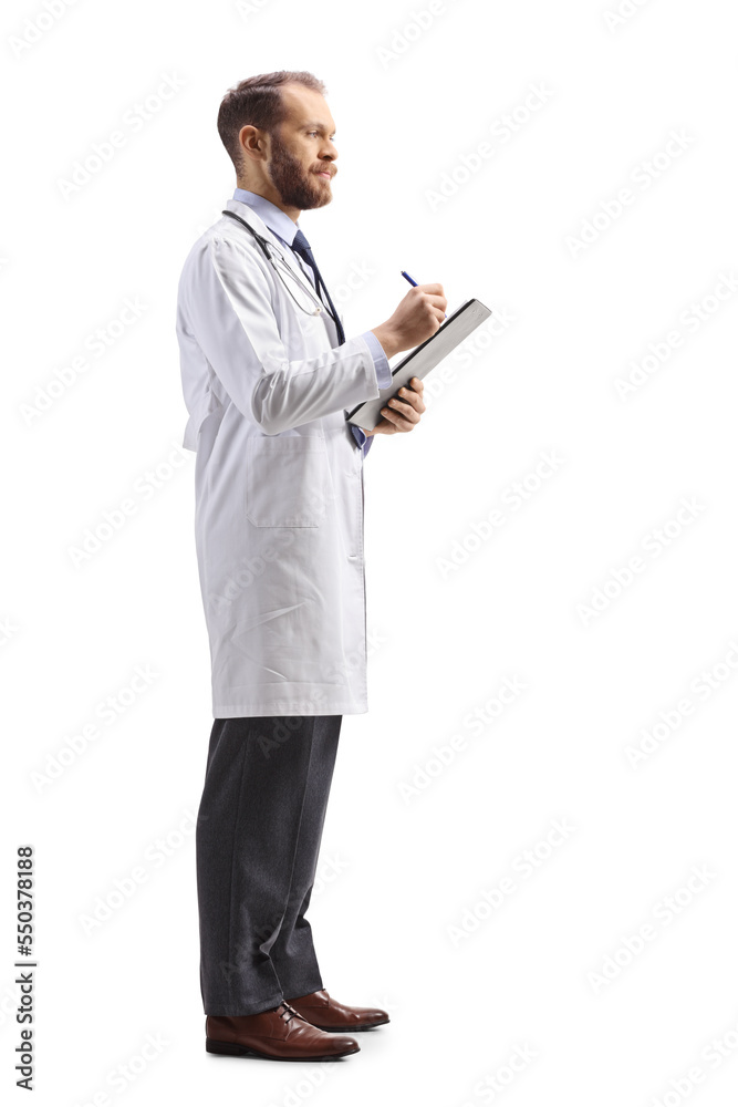 Full length profile shot of a male physician standing and writing a document