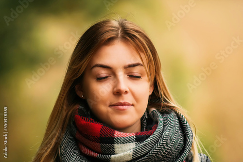 Young blond woman, blurred autumn background.