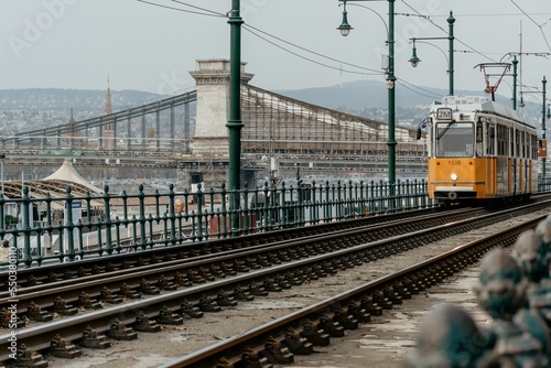 Orange tram moving on the bank of Danube river in Budapest in autumn, Hungary