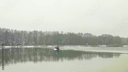 A rescue team is sailing on a hovercraft to rescue fishermen on the frozen lake, river or sea. The boat can move equally on water, on ice and even on land. photo