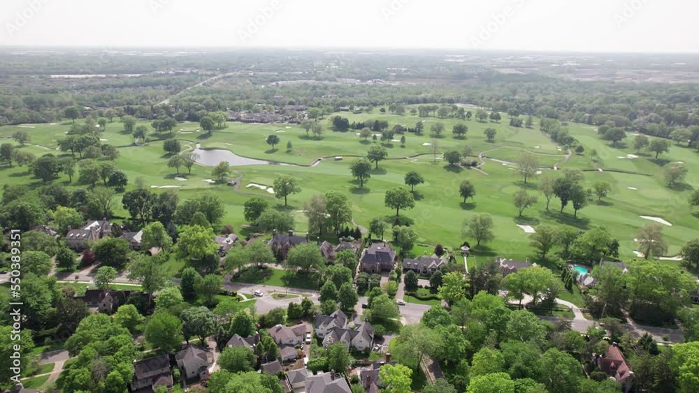 Suburban sprawl in Ohio with upper class homes, estates, and mansions next to big golf course lawn, many trees, and greenery park for golfing, holes, and players in Midwest, United States Suburban sprawl in Ohio with upper class homes, estates, and mansions next to big golf course lawn, many trees, and greenery park for golfing, holes, and players in Midwest, United States