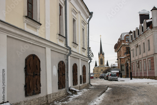 Architecture old medieval town Lutsk Ukraine. Winter view on old city paving stone street and history buildings. National landmark in snow. Tourist famous attraction.