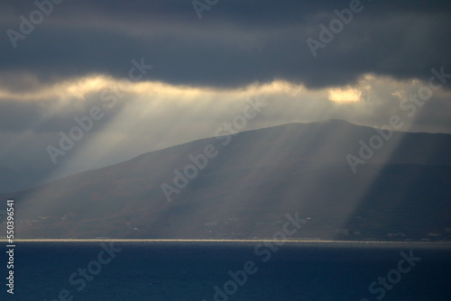the sun rays shine through the clouds on the sea surface