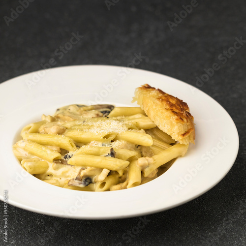 Alfredo pasta served in dish isolated on table top view of fastfood