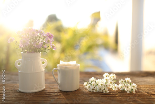 Tea cup on aster flowers on wooden table and