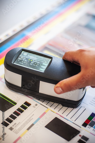Фотография X-Rite handheld spectrophotometer verify color patches, modern press shop prepress department
