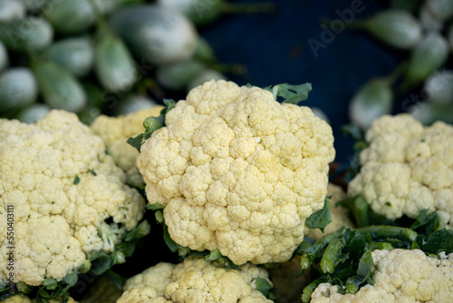 Cauliflower with green coverage leaves a closeup
