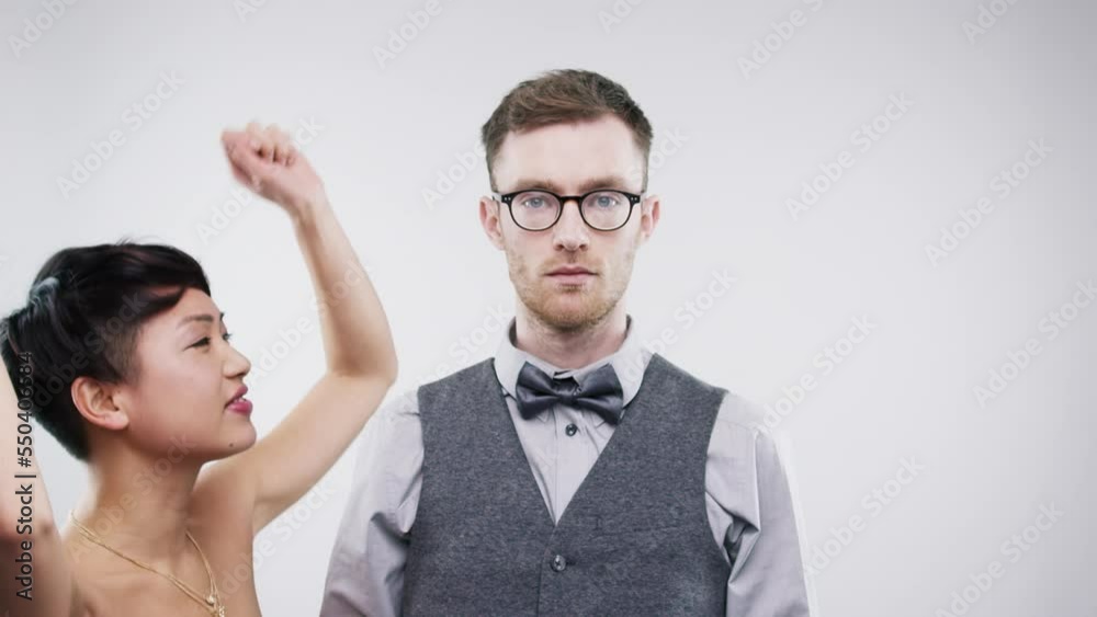 Asian woman dancing, serious man and celebration with party, music and portrait in white studio background with mockup. Crazy female, dance and m unsmiling male, music. and contrast in personality Asian woman dancing, serious man and celebration with party, music and portrait in white studio background with mockup. Crazy female, dance and m unsmiling male, music. and contrast in personality