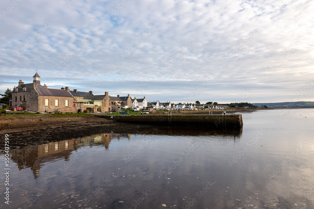 30 November 2022. Findhorn,Moray,Scotland. This is the Buildings on the beach of the bay being reflected on the water in the sea.