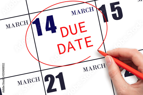 Hand writing text DUE DATE on calendar date March 14 and circling it. Payment due date