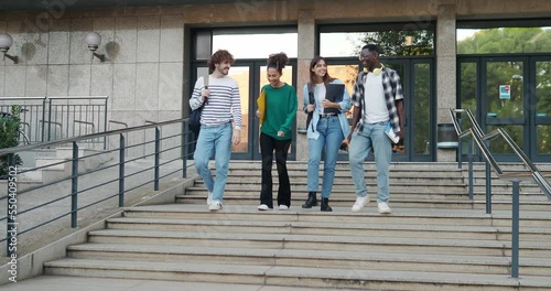Group of diverse college students talking to each other and walking on campus