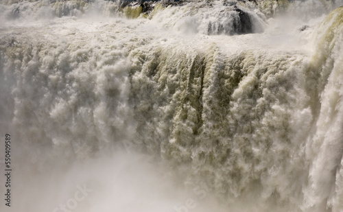Falling water background. Closeup view of the famous Iguazu falls in Misiones, Argentina. The mist and falling white water beautiful texture, motion and pattern.