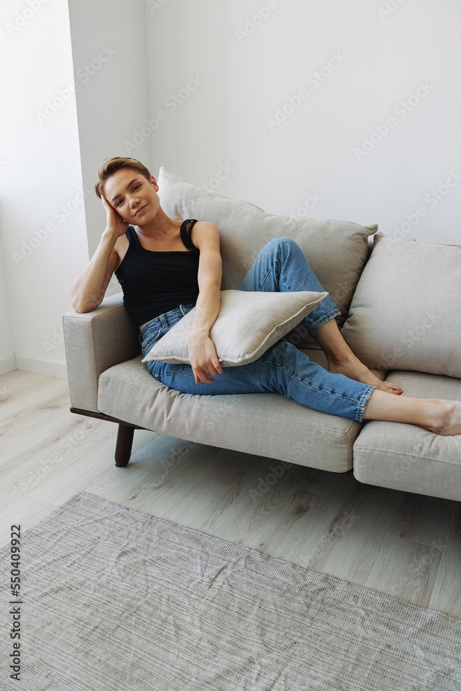 Young woman with short haircut hair having fun at home on the couch smile and happiness, vacation at home, natural posing without filters, free copy space Young woman with short haircut hair having fun at home on the couch smile and happiness, vacation at home, natural posing without filters, free copy space