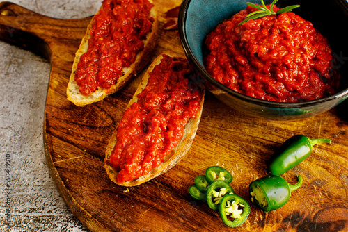 Slices of fresh bread spread with homemade lutenica photo