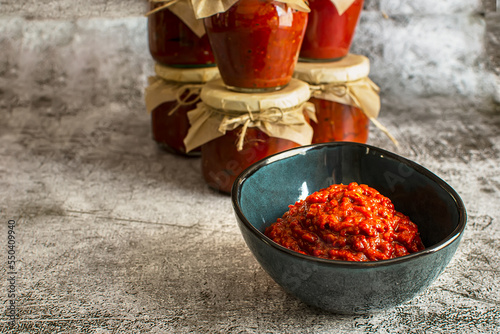A bowl of homemade lutenica and jars of the same