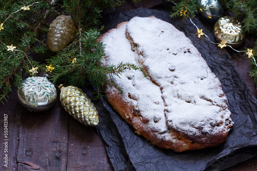 Obraz na płótnie Christmas stollen with dried fruits, nuts and spices, Christmas decorations on a dark wooden background. Rustic style. w salonie