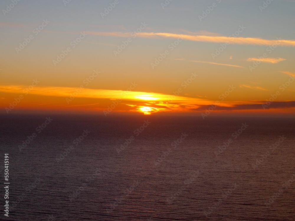 Obraz premium Sunset through the clouds over the Pacific Ocean