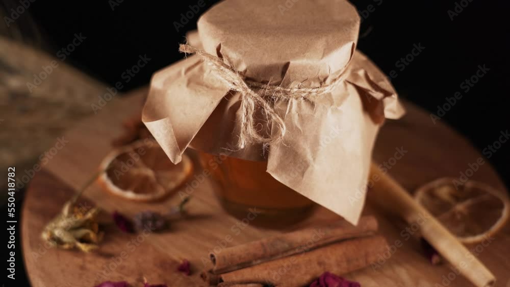 Glass jar with honey isolated on black background.The concept of honey products 4k Glass jar with honey isolated on black background.The concept of honey products 4k