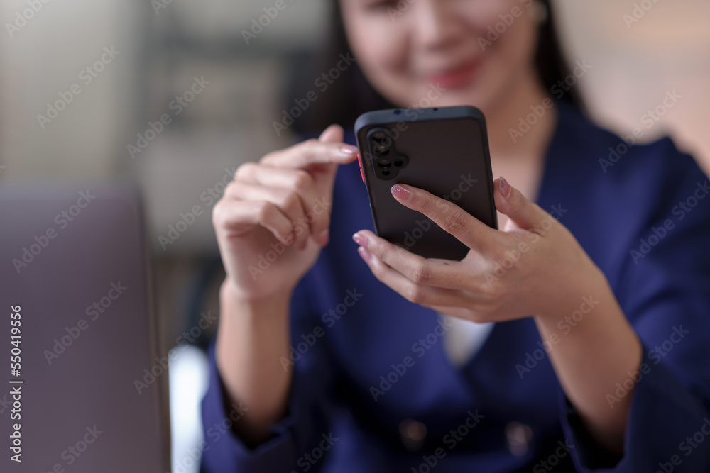 Smiling and attractive Asian woman using smartphone to play social media applications and conduct mobile banking. Smiling and attractive Asian woman using smartphone to play social media applications and conduct mobile banking.