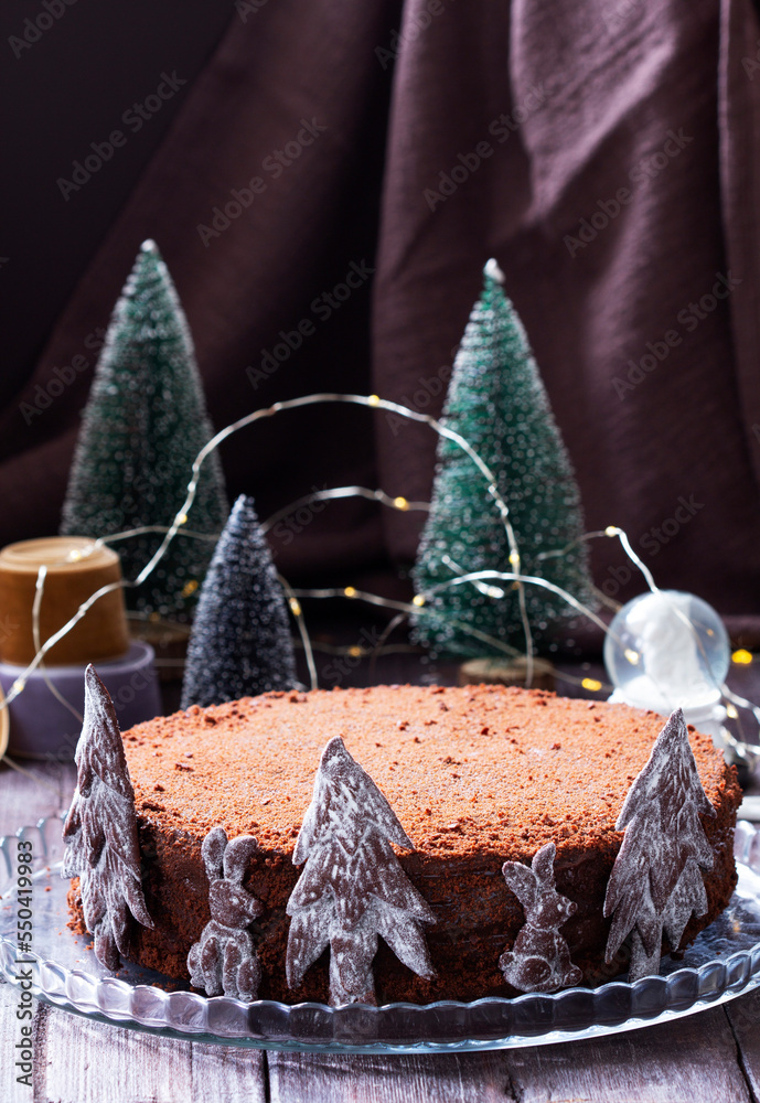 Chocolate honey cake in a Christmas decoration on a wooden background.