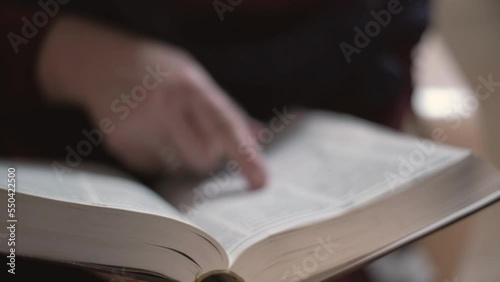 Woman in a dark room flipping through a book or dictionary preparing for an exam photo