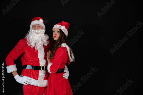  Portrait vom Weihnachtsmann und seiner Weihnachtsfrau auf schwarzen Hintergrund mit Platzhalter