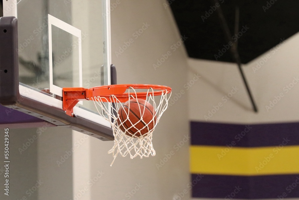 basketball swishing through net with purple background
