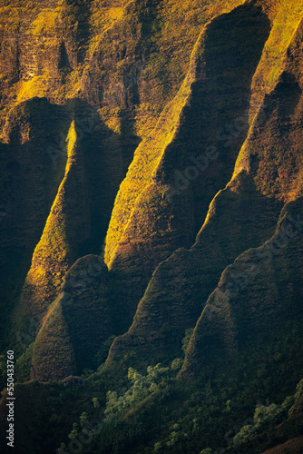 Sunset light illuminates the fin shaped mountains along the Na Pali coast in Kauai.