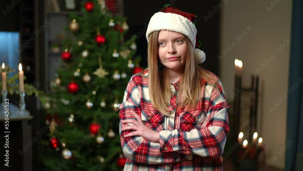 Sad lonely Caucasian woman sighing crossing hands standing in living room on Christmas eve. Portrait of upset beautiful lady thinking celebrating holiday alone at home Sad lonely Caucasian woman sighing crossing hands standing in living room on Christmas eve. Portrait of upset beautiful lady thinking celebrating holiday alone at home