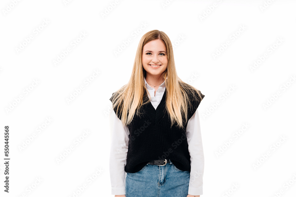 a blonde with sequins on face in jeans and a knitted vest on a white background. a blonde with sequins on face in jeans and a knitted vest on a white background.