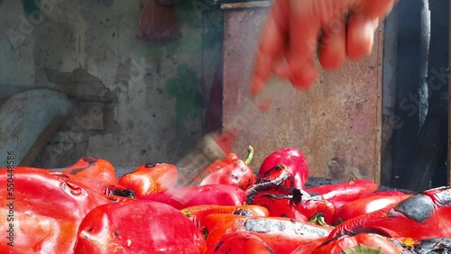 Roasting red peppers for a smoky flavor and quick peeling. Thermal processing of the pepper crop on metal circle. Brazier container used to burn charcoal fuel for cooking or heating. Bulgarian pepper photo