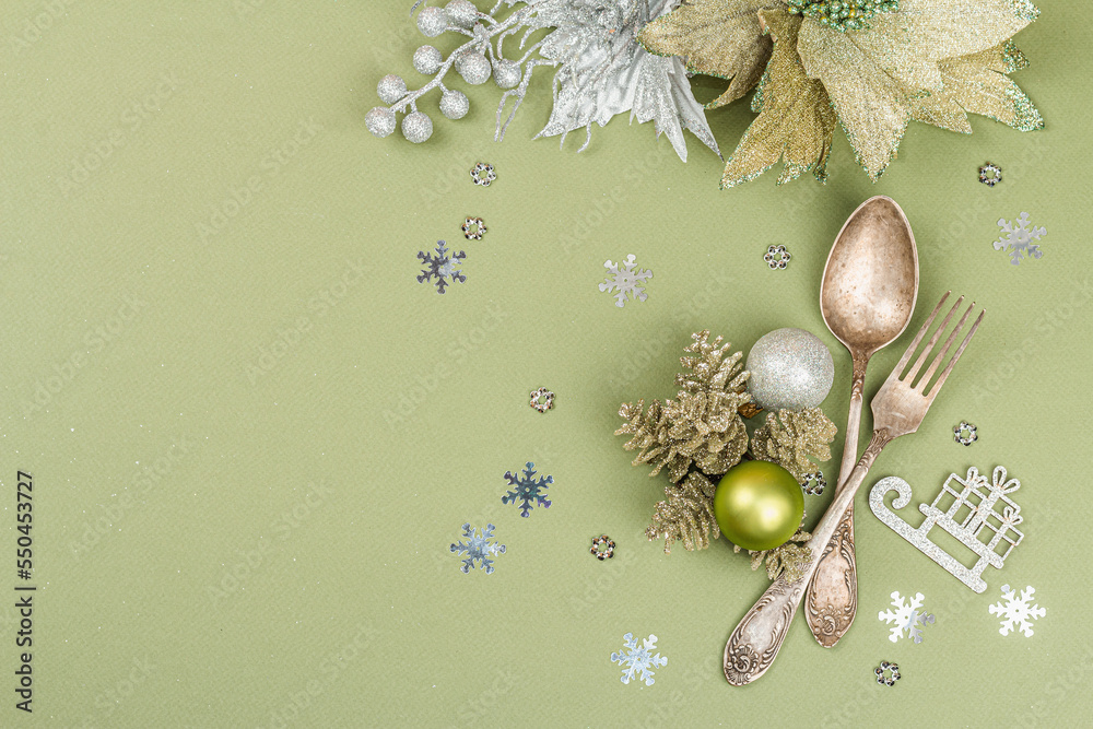 Christmas table setting with ceramic plates, traditional decor on Savannah Green color background Christmas table setting with ceramic plates, traditional decor on Savannah Green color background