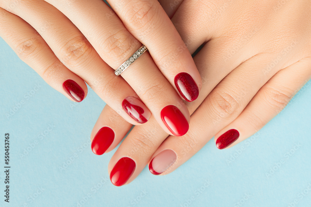 Womans hands with trendy red shiny manicure. Beauty treatment spa body care concept Womans hands with trendy red shiny manicure. Beauty treatment spa body care concept