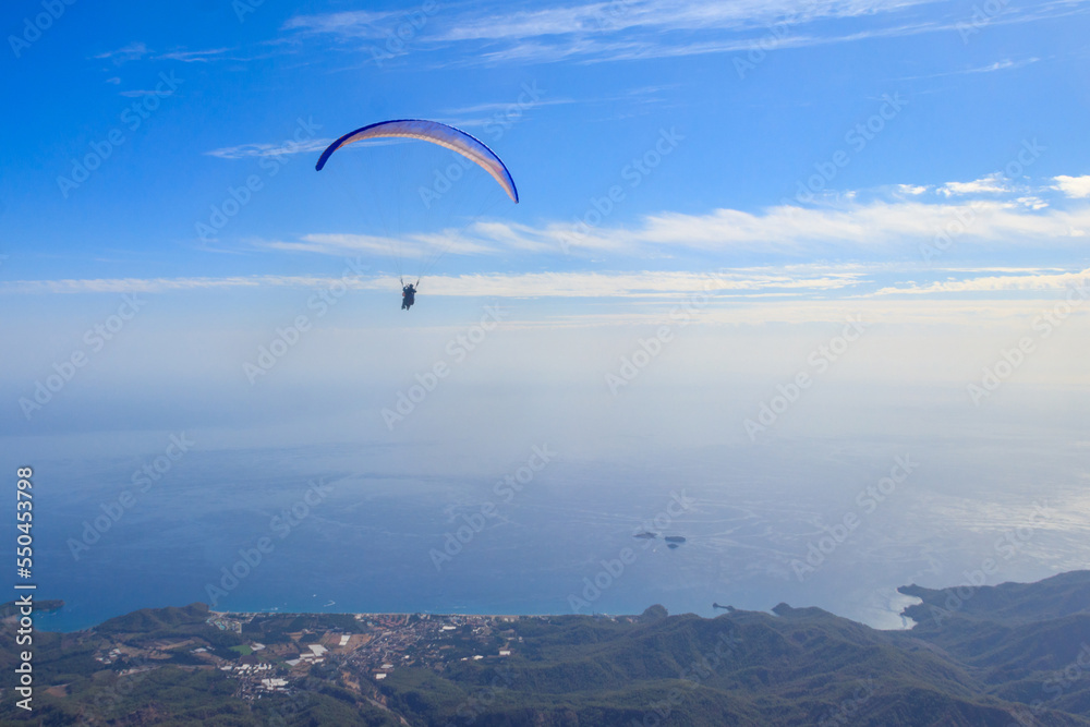 Paragliders flying from a top of Tahtali mountain near Kemer, Antalya Province in Turkey. Concept of active lifestyle and extreme sport adventure Paragliders flying from a top of Tahtali mountain near Kemer, Antalya Province in Turkey. Concept of active lifestyle and extreme sport adventure