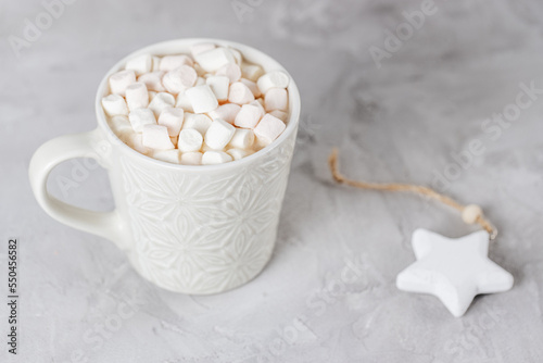 Cup of hot cocoa and marshmallows, gray background