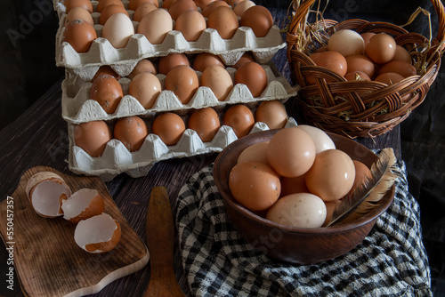 Chicken eggs in a clay plate and trays on the table