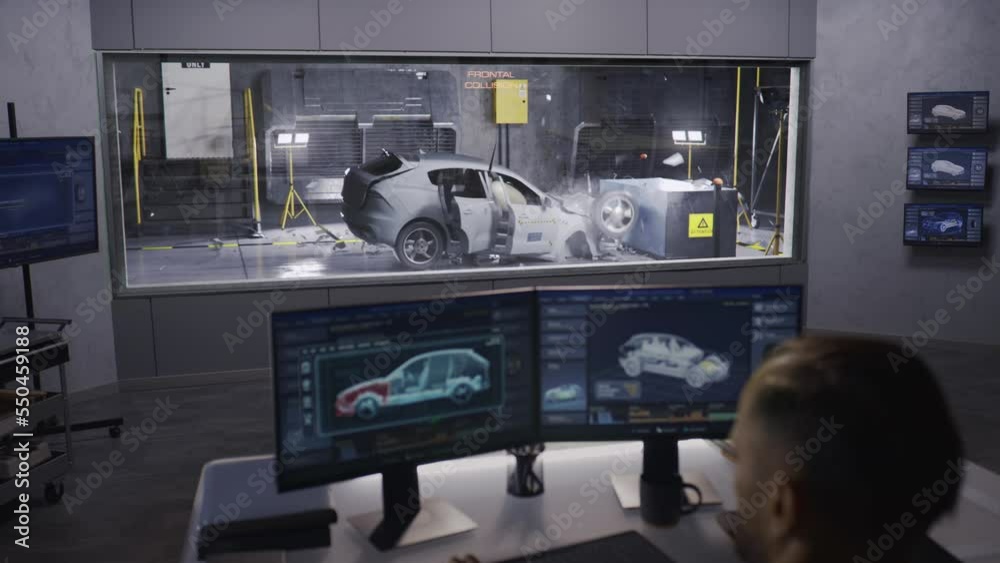 An engineer in a crash test lab uses a car crash test system to simulate a traffic accident, to obtain the safety parameters of an eco-friendly cutting edge electric vehicle being developed.