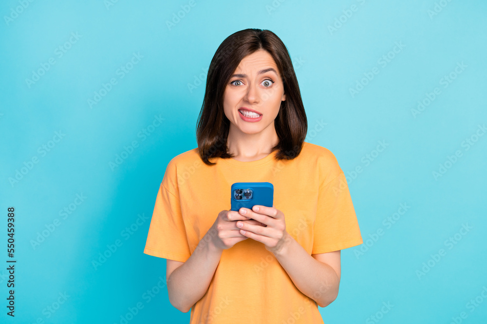 Portrait of unsatisfied person grin teeth hold use telephone isolated on blue color background